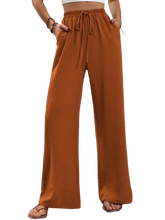 Wide leg drawstring pants made of 100% polyester with an opaque finish and machine washable design