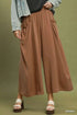 Woman wearing Umgee flowy wide leg pants with side pockets and drawstring waist