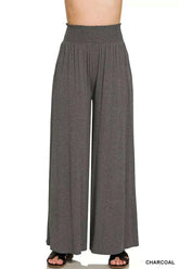 Woman wearing Zenana Smocked Waist wide leg palazzo pants with drawstring pockets and flowy silhouette