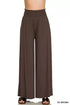 Woman wearing smocked waist wide leg palazzo pants with pockets in a relaxed, flowy style