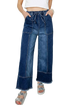 Close-up of raw hem wide leg denim pants with drawstring seam detail